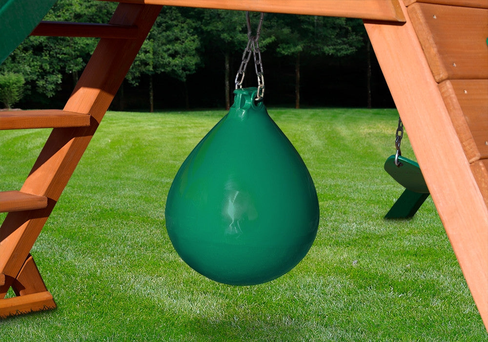 Lifestyle shot of green punching ball hanging underneath swing set.